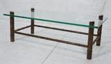 Lot 195:  BAKER style Faux Bamboo Gilt Metal Cocktail Table. 3/4" thick Glass Top on Thick "Bamboo" Column Legs & Frame.: Dimensions:  H: 16 inches: W: 51 inches: D: 26 inches --- 