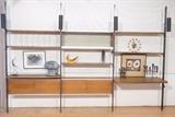 Lot 327:  CSS by George Nelson Modernist Wall Shelf Unit. Four uprights with Black tubular lights. Four units for storage. Shelves. Wood desk surface. Aluminum trim. HERMAN MILLER. : Dimensions:  H: 98.5 inches: W: 144 inches: D: 24 inches --- 