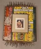 Lot 385:  WAYNE MOON GIRL Mixed Media Found Object Frame. Olive Oil & Tomato paste can frame.: Dimensions:  H: 20 inches: W: 14 inches --- 
