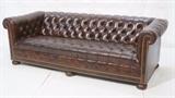 Lot 424:  Larger Brown Leather Chesterfield Sofa Couch. Wood bun feet. Tufted with metal studs.: Dimensions:  H: 29 inches: W: 87 inches: D: 36.5 inches --- 