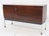 Lot 434:  BNDB N.H. cP Rosewood Credenza. Three Drawer. One Door. Chrome pull. Raised on chrome Legs with rosewood capped feet. Marked as shown. : Dimensions:  H: 30.5 inches: W: 51.25 inches: D: 17 inches --- 