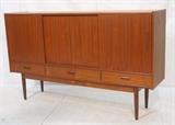 Lot 505:  Danish Modern Teak Cabinet Raised on Legs. Three drawers below four sliding doors. : Dimensions:  H: 44.25 inches: W: 75 inches: D: 17 inches --- 