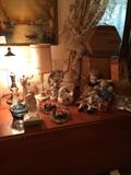 Close up of the maple drop leaf table with pottery, lamps, dolls, art work.