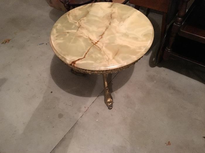 Round coffee table with onyx top, purchased in France, gold metal legs w/ dolphin feet.