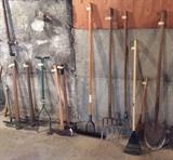Yard tools galore - pick axe, axes, pitchfork, rakes