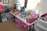 Tables of toys including Barbies and accessories, Disney VHS tapes. Robot transformers, Weebles, puzzles and table lamps.