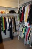 Walk in closet full of ladies clothing.