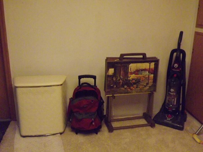 Vintage hamper, backpack filled with bocce balls, vintage TV trays, Dirt Devil upright vacuum cleaner