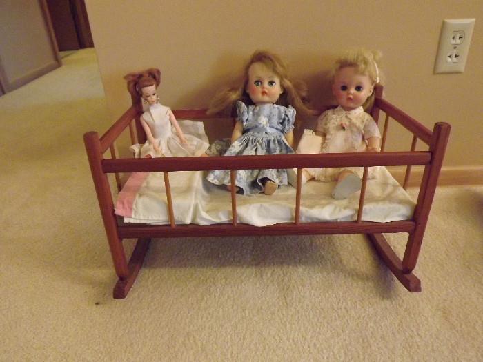 Barbie and Horsman dolls in a doll cradle