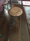 one of 4 wrought iron bar stools with fabric seating.