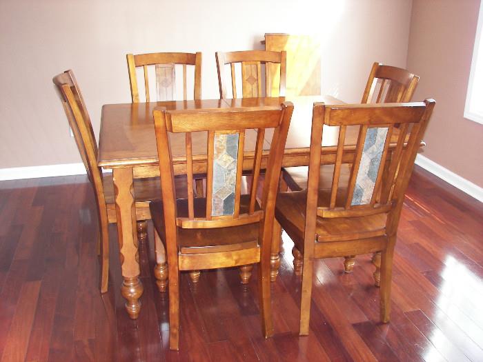 Dining table with leaf and six chairs. Notice detail of inlaid slate on chair back