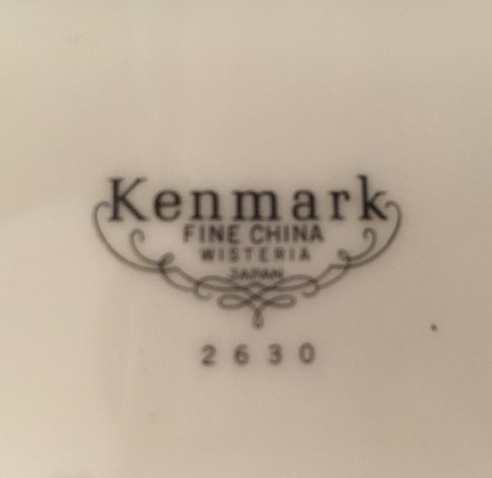 Large set of like-new Kenmark fine china--some pieces wrapped in original bags and tissue paper. Set includes 12 five-piece place settings and several completer pieces.
