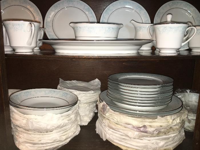 Large set of like-new Kenmark fine china--some pieces wrapped in original bags and tissue paper. Set includes 12 five-piece place settings and several completer pieces.