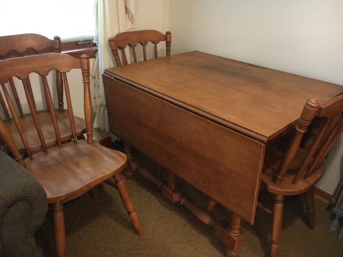 Vintage maple drop leaf table with pads and 4 chairs.