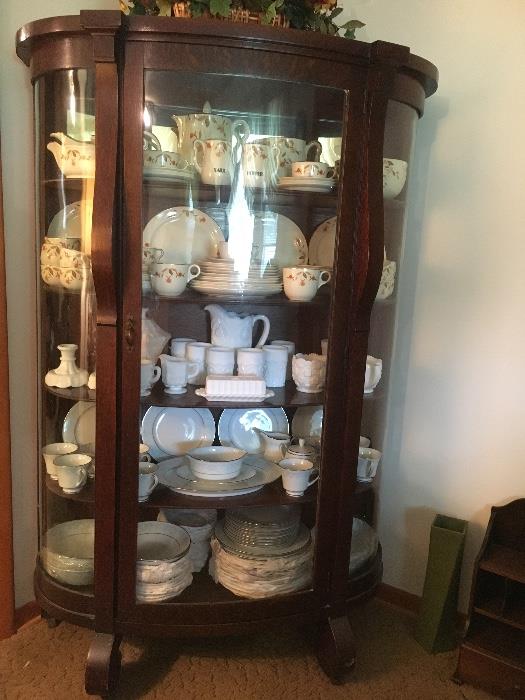 Antique Empire style oak china cabinet with curved glass door and sides. NOTE: The right glass panel is damaged in the lower back corner. See next photo.
