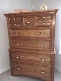 Sold oak bedroom group by Jamestown Sterling. Set includes large dresser with 3-way mirror, chest on chest, two nightstands and queen size bed. Just replace the hardware for a quick update.