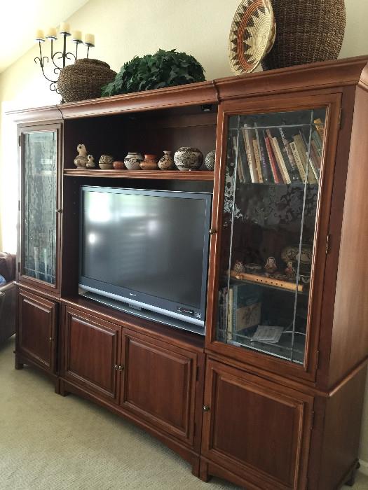 Beautiful entertainment center with glass doors on top and 4 cabinets on the bottom