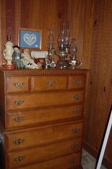 Tall wood chest of drawers. Antique oil lamp collection. 