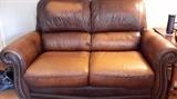Distressed leather loveseat and sofa with studs