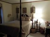 Mahogany poster bed with Sleep number mattress, baskets, side table, floor lamp, prints, dresser with mirror