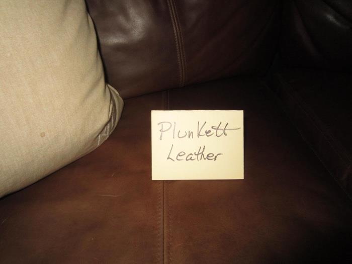 Plunkett leather loveseat with brass nailhead embellishments