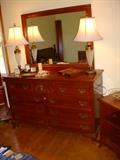 Kling cherry dresser with mirror, and night stand partially visible to the right