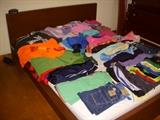 Children's clothing displayed on a Queen size platform bed