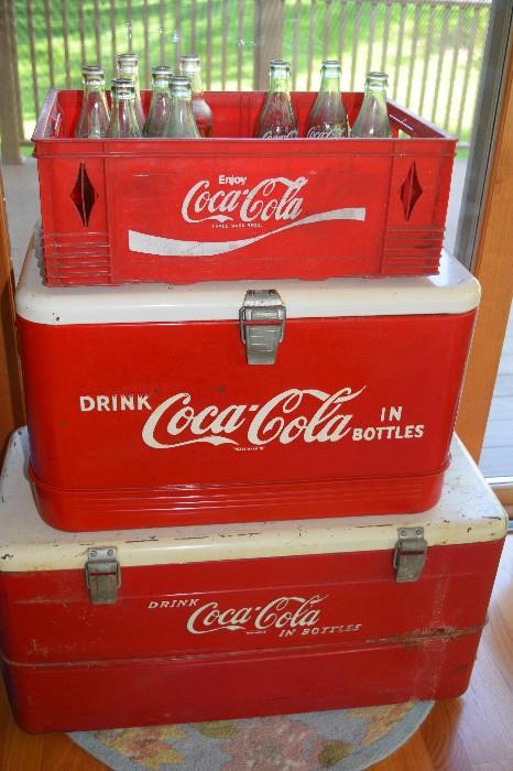 Vintage Coca~Cola coolers and plastic bottle holder holding soda bottles. 