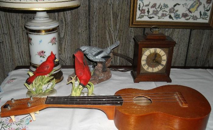 Collectible bird figurines and Ukelele, several nice, framed needlepoints,