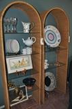Fabulous arched wicker display units with glass shelves.  On the bottom shelf is "Mugs in Sunlight" Lithograph, signed and numbered by Deborah L. Chabrian with COA