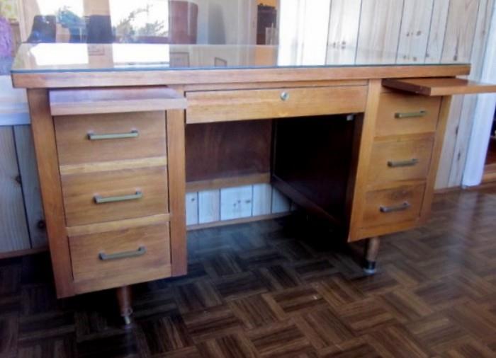 Mid Century Modern desk by Indiana Desk Co., USA.  Has 6 drawers, 2 pull-out writing shelves and custom glass top.  Measures 50" wide, 26" deep, 29-1/2" tall.  (There are two of these available).