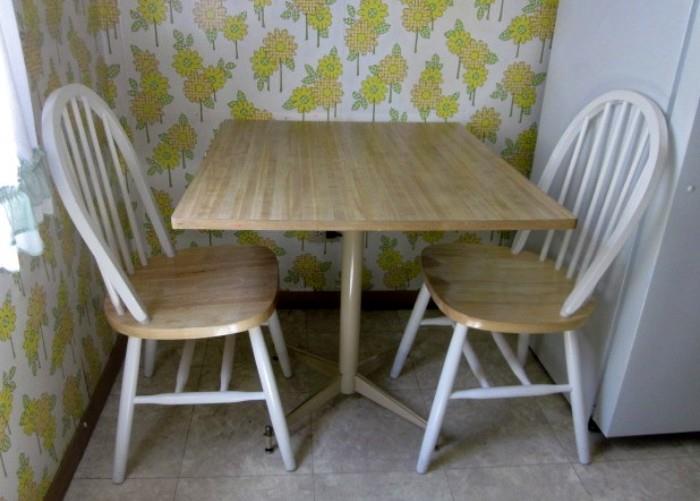 Small kitchen table, metal pedestal base, with two chairs.