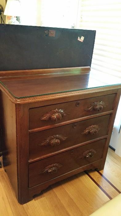 revival style 3 drawer chest with carved pulls and glass top