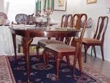 Queen Anne mahogany dining table and six chairs.  Table has three additional leaves