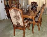 Dining table with plush chairs, etched colored crystal wine glasses, crystal handleholders. 