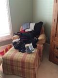 Club chair and matching ottoman loaded with snow ski equipment and outer wear