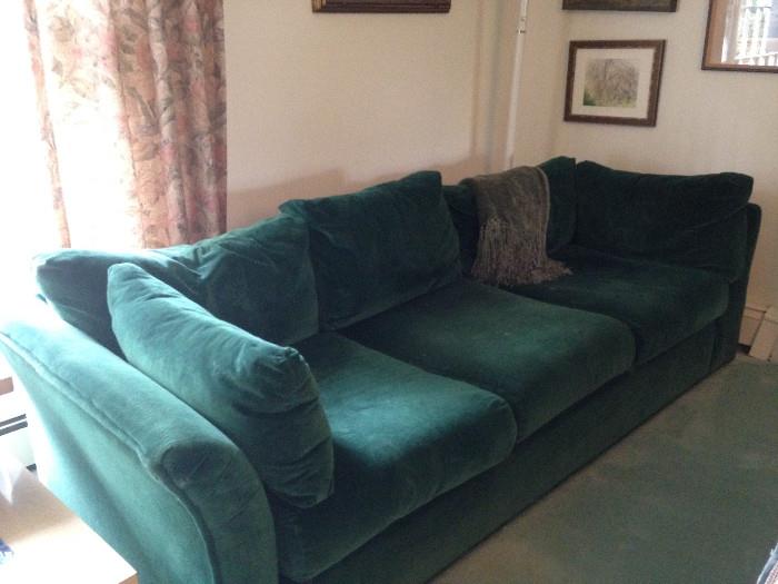 Green velour sofa, which can be put together with the loveseat in the next frame as a sectional.