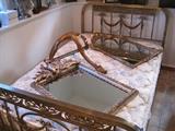 A French Louis XVI style brass bed. Ornate gilt mirrors.