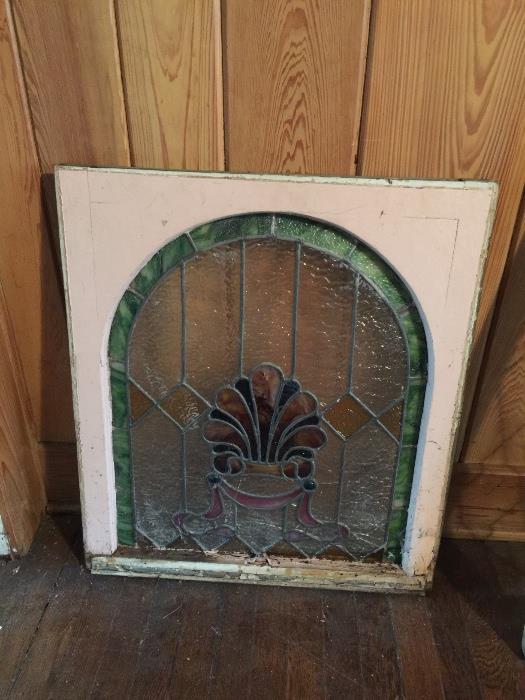 Rounded stained glass window, wood needs repair but glass is intact