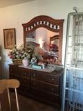 Larger dressing table with mirror, floral, pottery, and glass