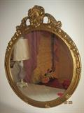 Ornately carved, antique wooden, gold painted round wall hanging mirror.