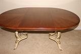 Handsome mahogany dining table with one extra leaf and protective cover. The base features an antiqued finish on French Provincial legs.