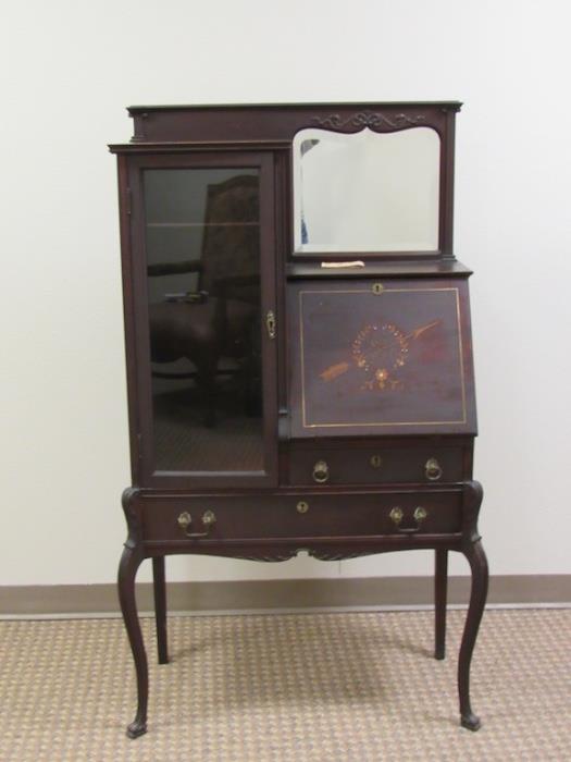 American Edwardian cabinet...early 20th century mahogany slant front secretary/china cabinet. Features beveled mirror inset above slant-front writing section inlaid with garland & arrow. Interior has pigeon holes and a small drawer flanked by a glass inset door...Sits on cabriole legs and pad feet.