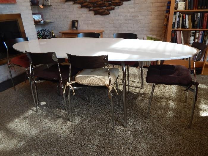 Italian laminate and chrome table with six chairs. Chairs are wooden seats with chrome legs.
