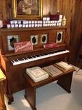 Story Clark Electric player piano with bench and includes over 30 rolls! the front glass panels light up even when not in use!