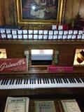 Story Clark Electric player piano with bench and includes over 30 rolls! the front glass panels light up even when not in use!