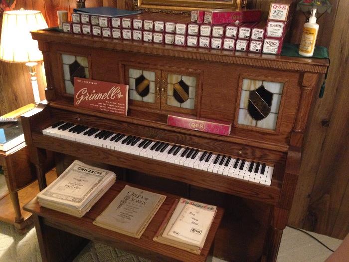 Story Clark Electric player piano with bench and includes over 30 rolls! the front glass panels light up even when not in use!