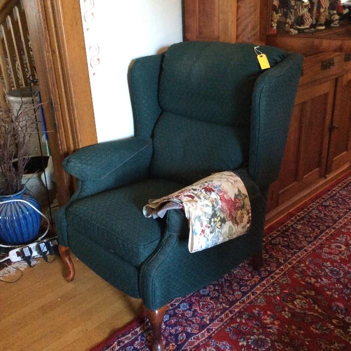 One of 2 forest green wingback recliners