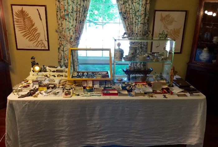 Table full of antiques, collectibles and jewelry.  