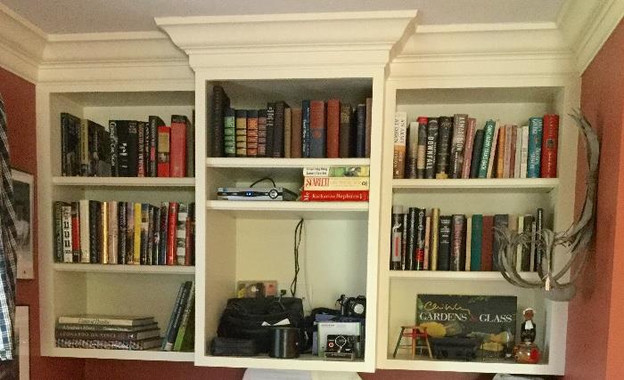 Shelves full of books and  cameras